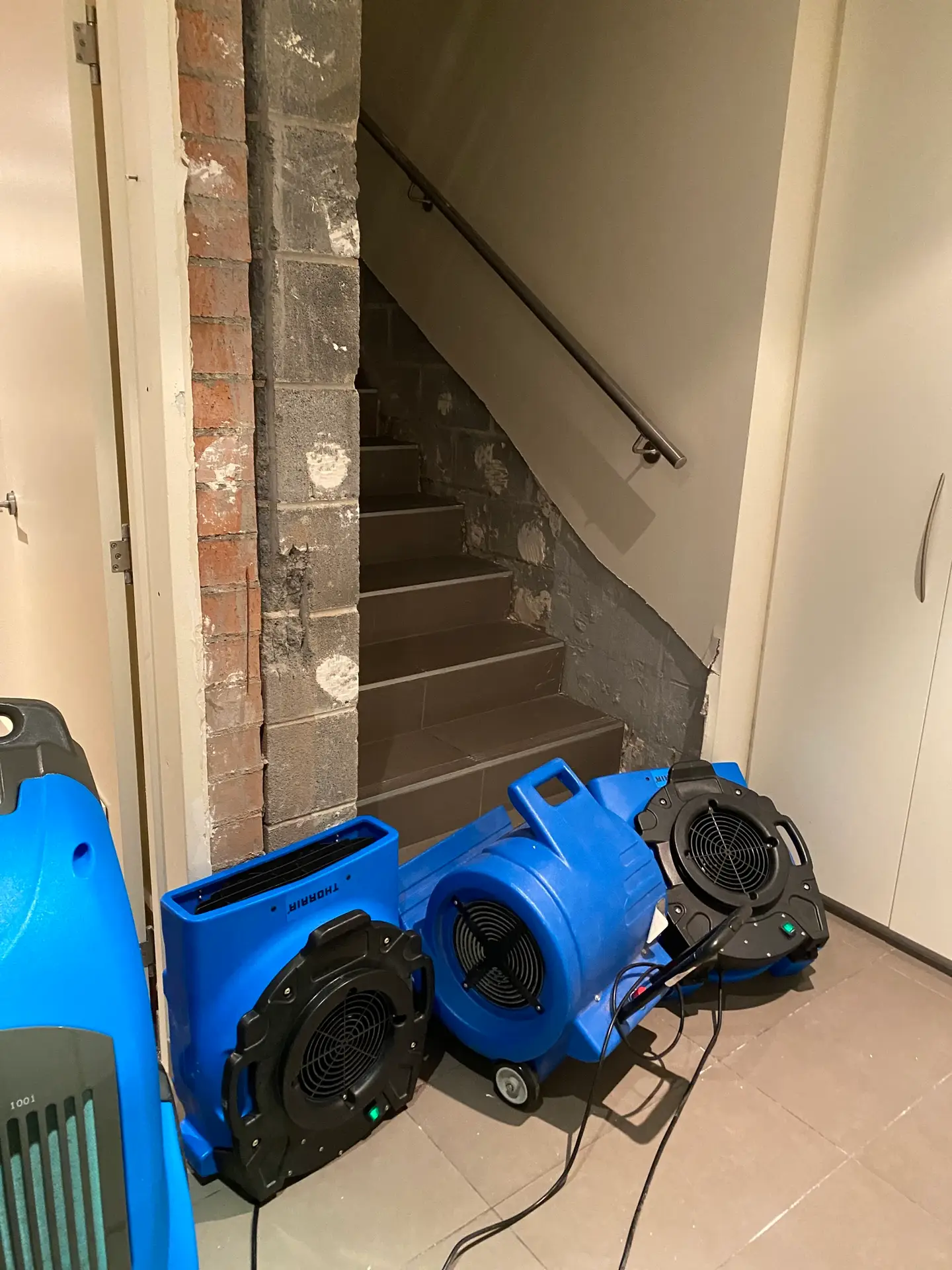 Air movers and dehumidifiers drying stairwell after water damage — Restored Right Sydney